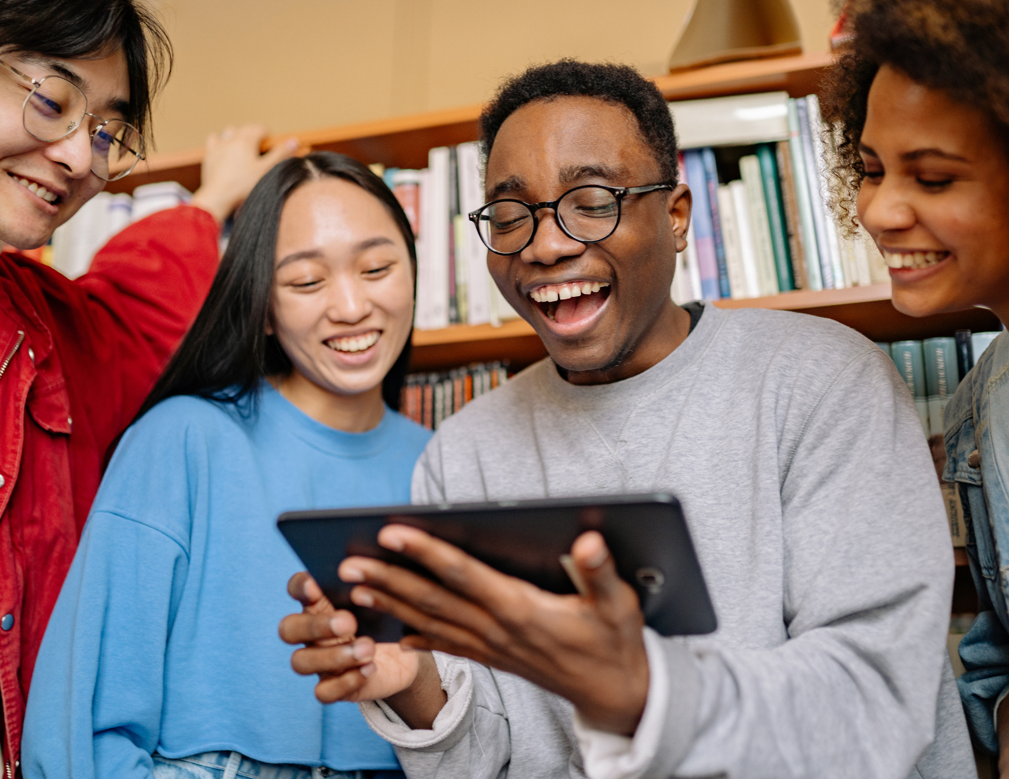 Four people looking at a smart device.